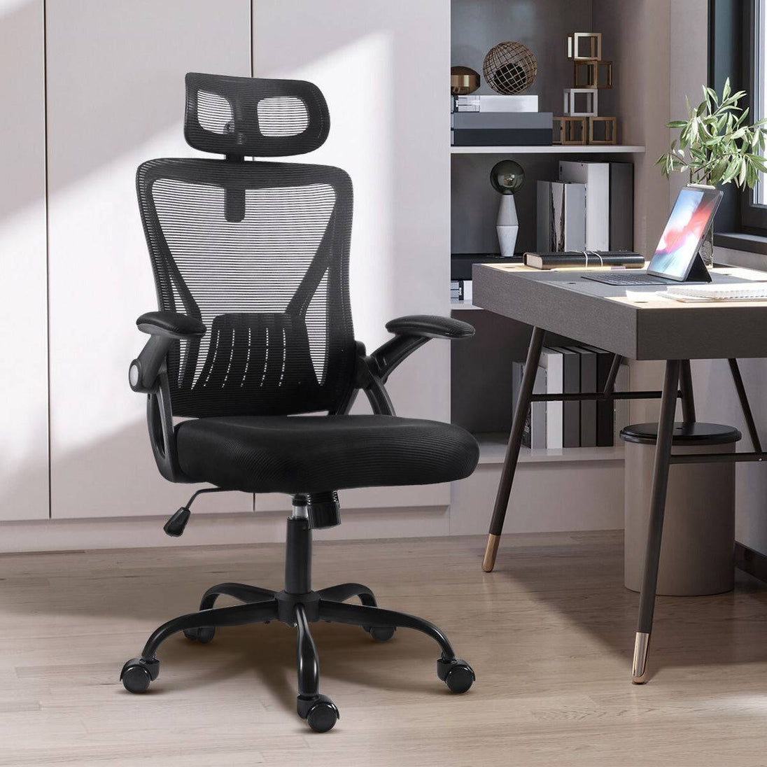 Black GGCIR Mesh Ergonomic Office Chair placed in a modern home office setup, showcasing its adjustable headrest and flip-up arms.